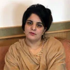 Dr. Surya Akbar wearing tan traditional attire.